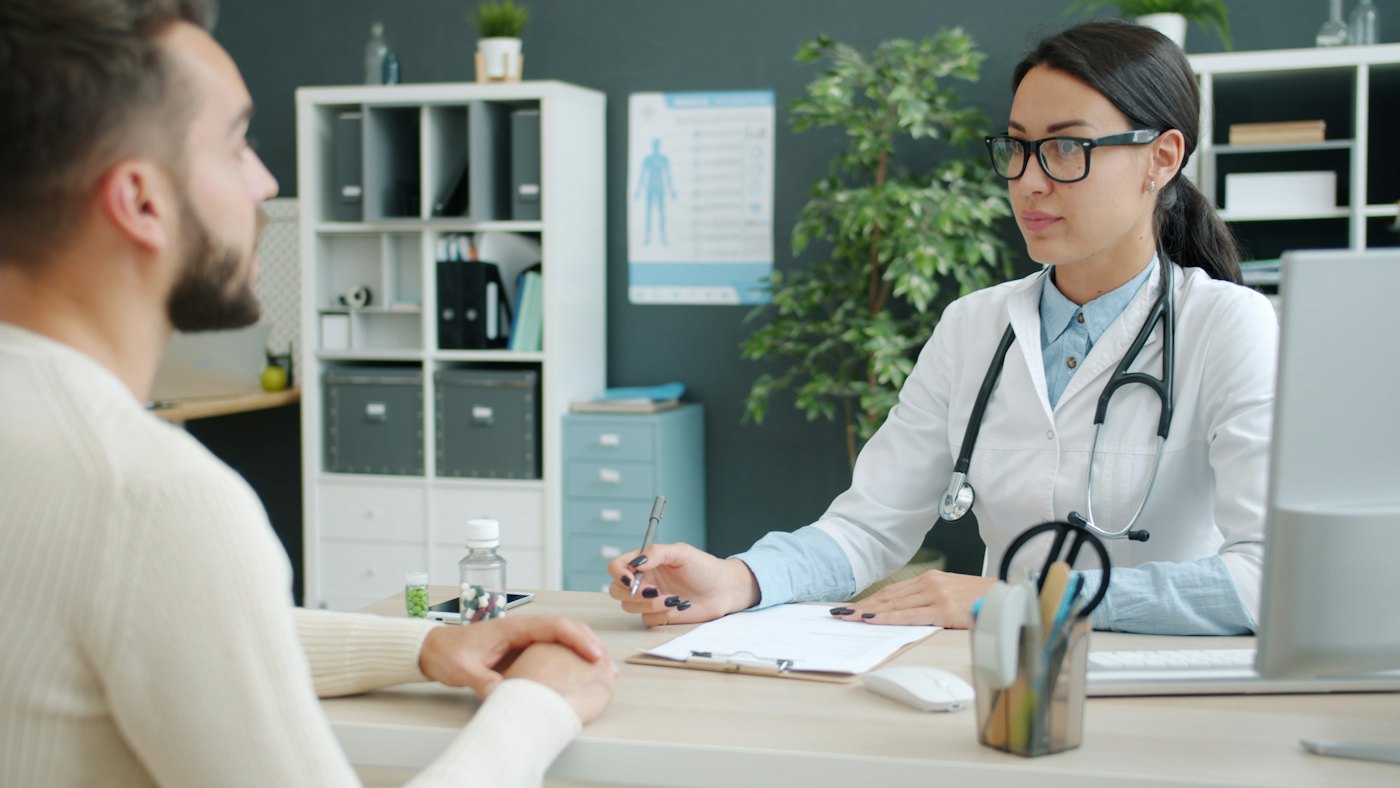 Doctor consulting with a patient across a clinic desk