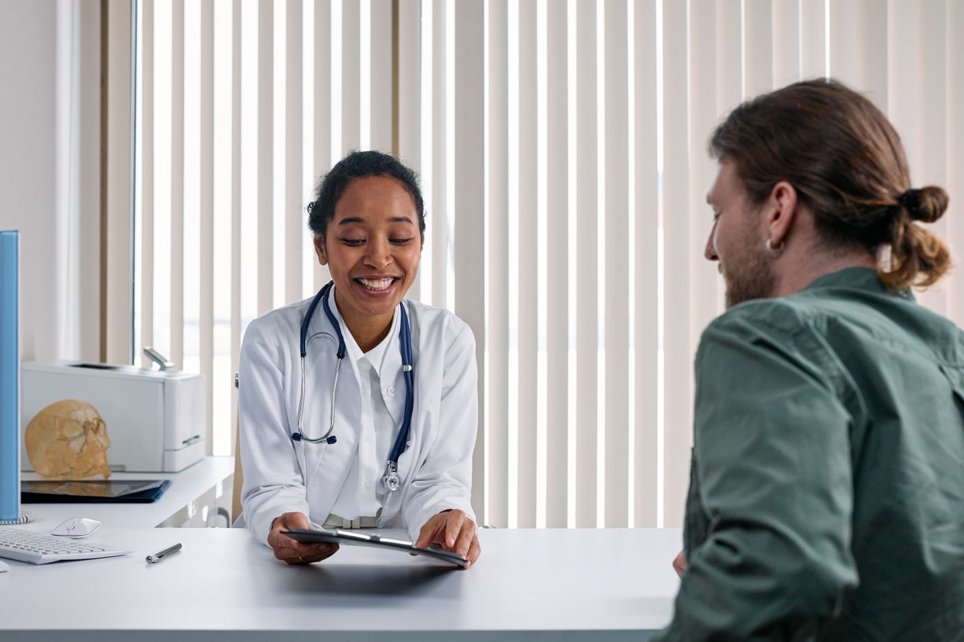 Clinician speaking with a patient at a clinic desk